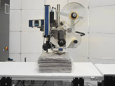 Labeler for applying labels onto the packed products